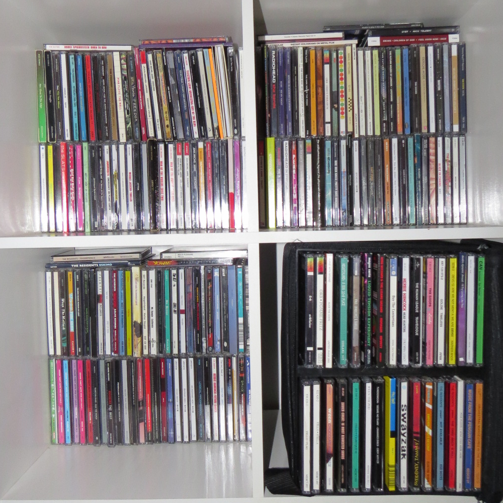 A shelf holding several Compact Discs.