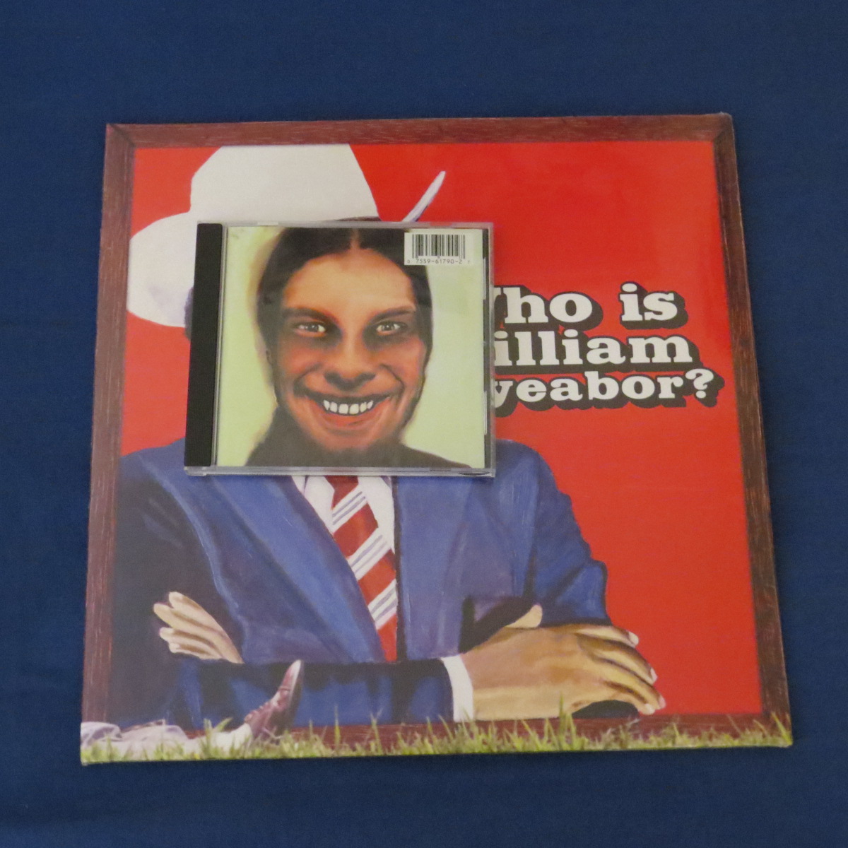 The same picture as last time, but with a CD copy of Aphex Twin's 'I Care Because You Do...' is placed over William's face. This is to demonstrate the size difference bettween the two.